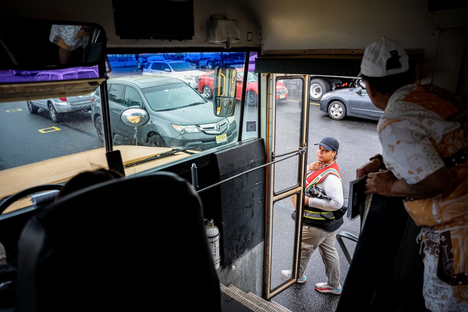 An instructor checks in on students practicing in a school bus at the Driving Academy on Tuesday, June 10, 2025 in Linden, N.J., where students prepare to obtain a Commercial Driver’s License (CDL) with multilingual instructors. (AP Photo/Angelina Katsanis)