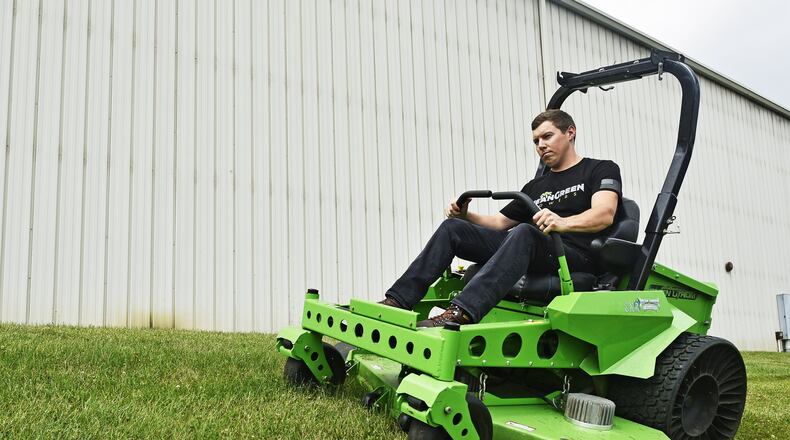 Matt Conrad cuts grass outside the Mean Green Mowers facility in 2019 in Ross Twp. FILE