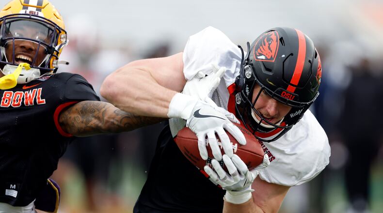 American tight end Luke Musgrave of Oregon State catches a pass over American defensive back Jay Ward of LSU during practice for the Senior Bowl NCAA college football game, Thursday, Feb. 2, 2023, in Mobile, Ala.. (AP Photo/Butch Dill)