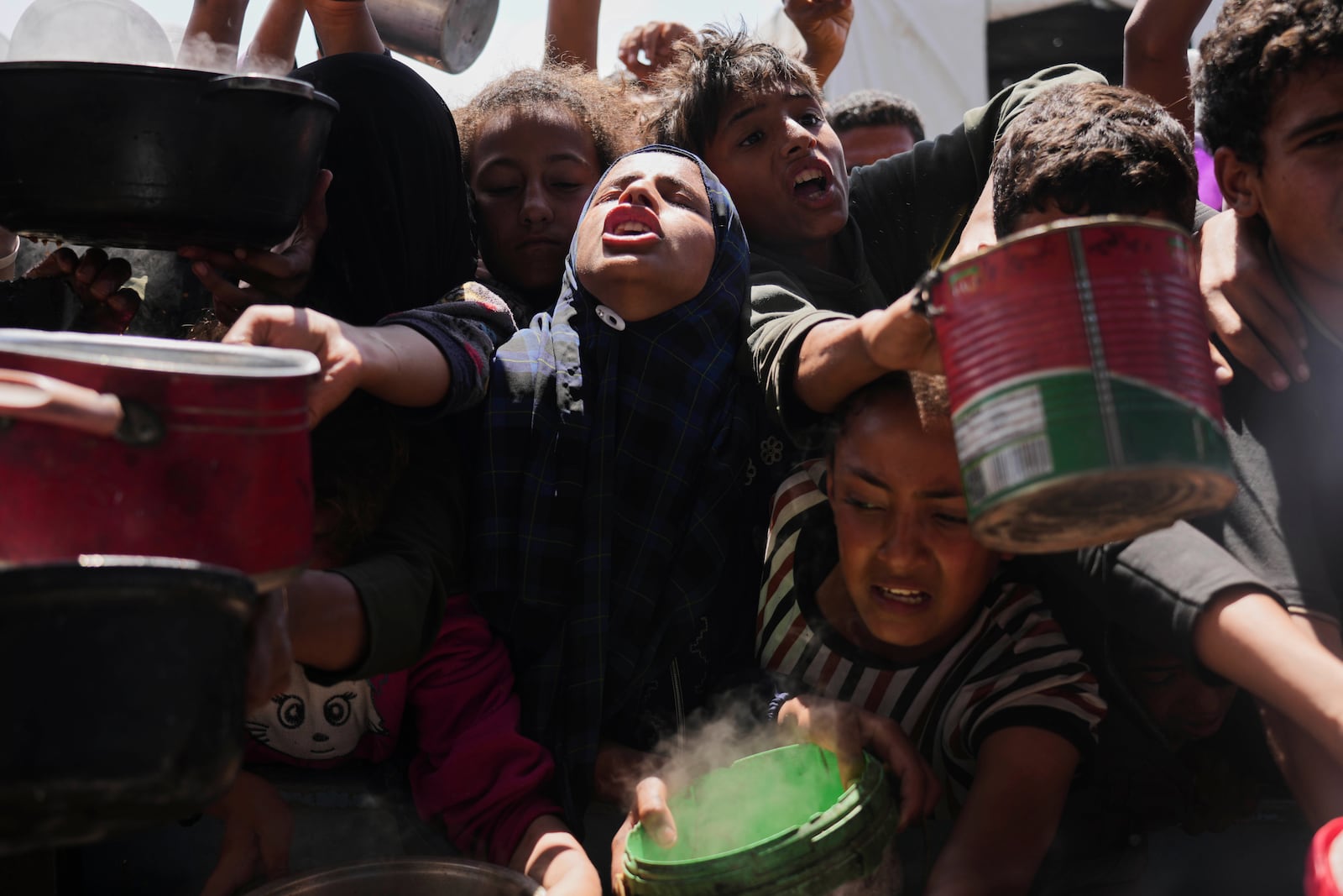Palestinians struggle to get donated food at a community kitchen in Khan Younis, Gaza Strip, Monday, May 5, 2025. (AP Photo/Abdel Kareem Hana)