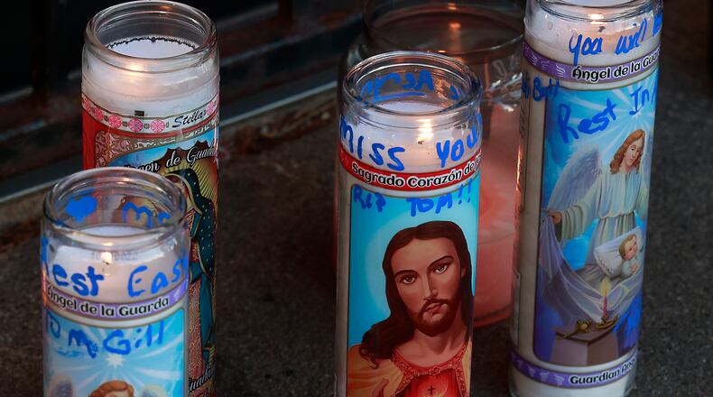 Family, friends and community members filled the parking lot of Gill's Quality Meat Market Monday, Jan. 9, 2023 during a candle light vigil for Thomas Gill, who was shot and killed while driving his SUV in Springfield. BILL LACKEY/STAFF
