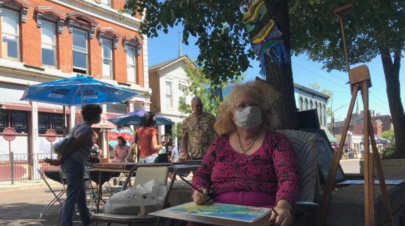 People enjoy the new pedestrian promenade on Fifth St. in the Oregon District on Saturday.