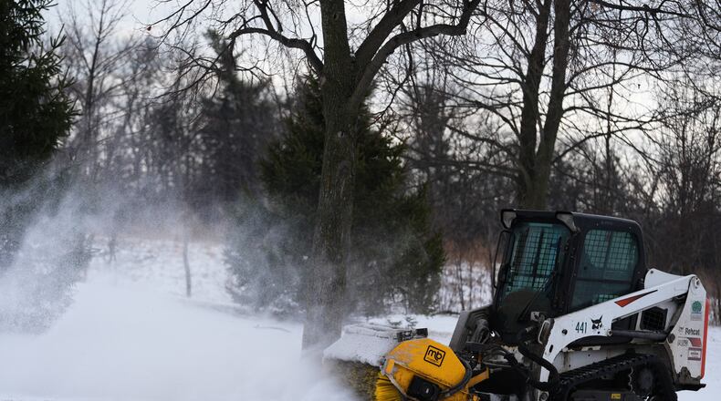 A plow clears snow from a snow-covered sidewalk during a cold day in Lake Forest, Ill., Wednesday, Jan. 21, 2026. (AP Photo/Nam Y. Huh)