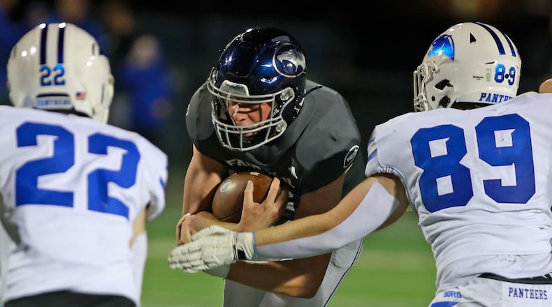 Fairmont's Brock Baker carries the ball between Springboro's Nolan Stringer, left, and Luke Cheatwood. BILL LACKEY/STAFF