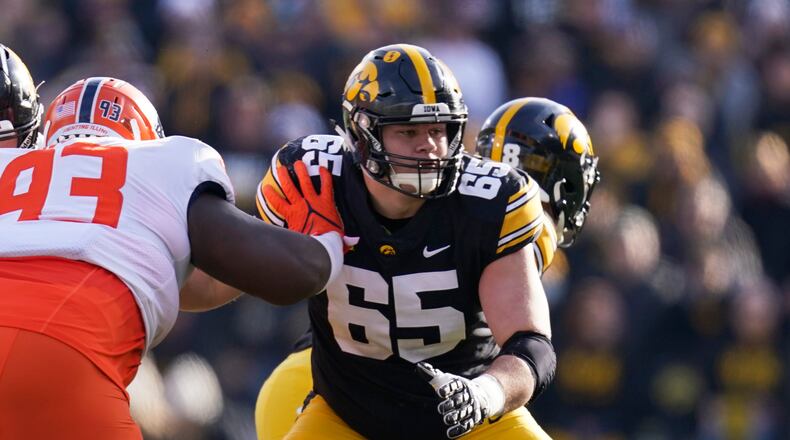 Iowa offensive lineman Tyler Linderbaum (65) looks to make a block during the first half of an NCAA college football game against Illinois, Nov. 20, 2021, in Iowa City, Iowa. (AP Photo/Charlie Neibergall)