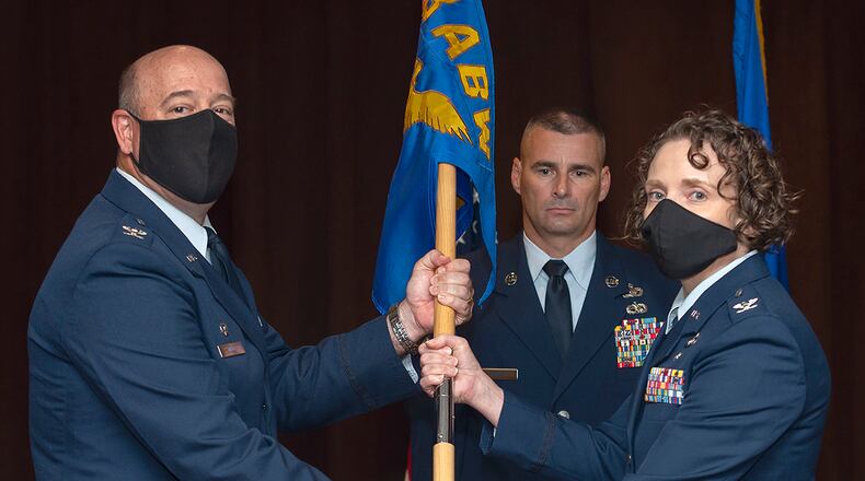 Col. Patrick Miller, 88th Air Base Wing and installation commander, presents the 88th Mission Support Group guidon to Col. Sirena Morris as she assumes command during a ceremony July 1 in the Wright-Patterson Club. U.S. AIR FORCE PHOTO/R.J. ORIEZ