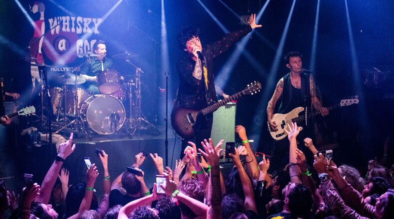 FILE PHOTO: (L-R) Tré Cool, Billie Joe Armstrong and Mike Dirnt of Green Day perform during the “Hella Mega Tour” announcement show at Whisky a Go Go on September 10, 2019 in West Hollywood, California. The tour has been canceled due to the coronavirus.
