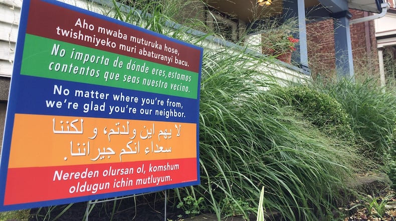 A sign outside a home in the South Park neighborhood sends a welcoming message to people who speak other languages. Dayton’s attitudes toward immigrants moving next door remain nearly unchanged from last year. CORNELIUS FROLIK / STAFF