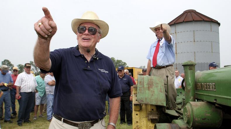 Horace J.R. Kramer (left) works the 10,000th auction of his career Thursday at the James H. Montgomery estate in Eaton in September 2005. Kramer held his first auction in 1948. At right is his son, John Kramer. Photo by Lisa Powell
