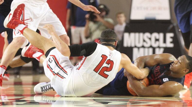 Dayton’s Kendall Pollard, right, and Davidson’s Jack Gibbs wrestle for a loose ball in the second half on Friday, Feb. 24, 2017, at Belk Arena in Davidson, N.C. David Jablonski/Staff