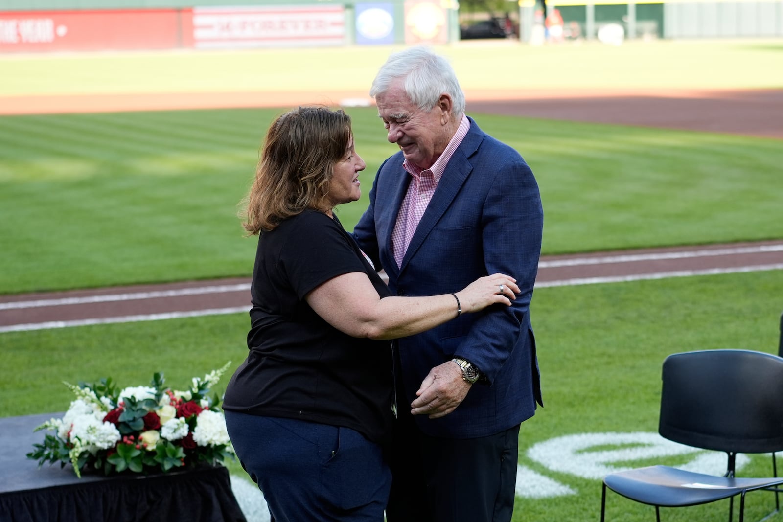 Cincinnati Reds owner Bob Castellini, right hugs Pete Rose's daughter Fawn Rose as they meet on the field for Pete Rose Night events before a baseball game between the Cincinnati Reds and the Chicago White Sox, Wednesday, May 14, 2025, in Cincinnati. (AP Photo/Carolyn Kaster)