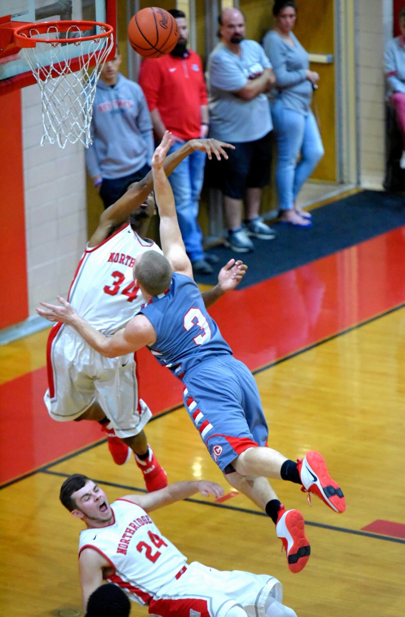 Carlisle’s Jake Moore knocks Northridge’s Seth Deaton (24) to the floor while Javoni Hill (34) takes a swipe at the ball during Friday night’s game at Northridge. NICK GRAHAM/STAFF