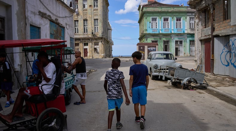 People walk outside during a blackout in Havana, Cuba, Monday, March 16, 2026. (AP Photo/Ramon Espinosa)
