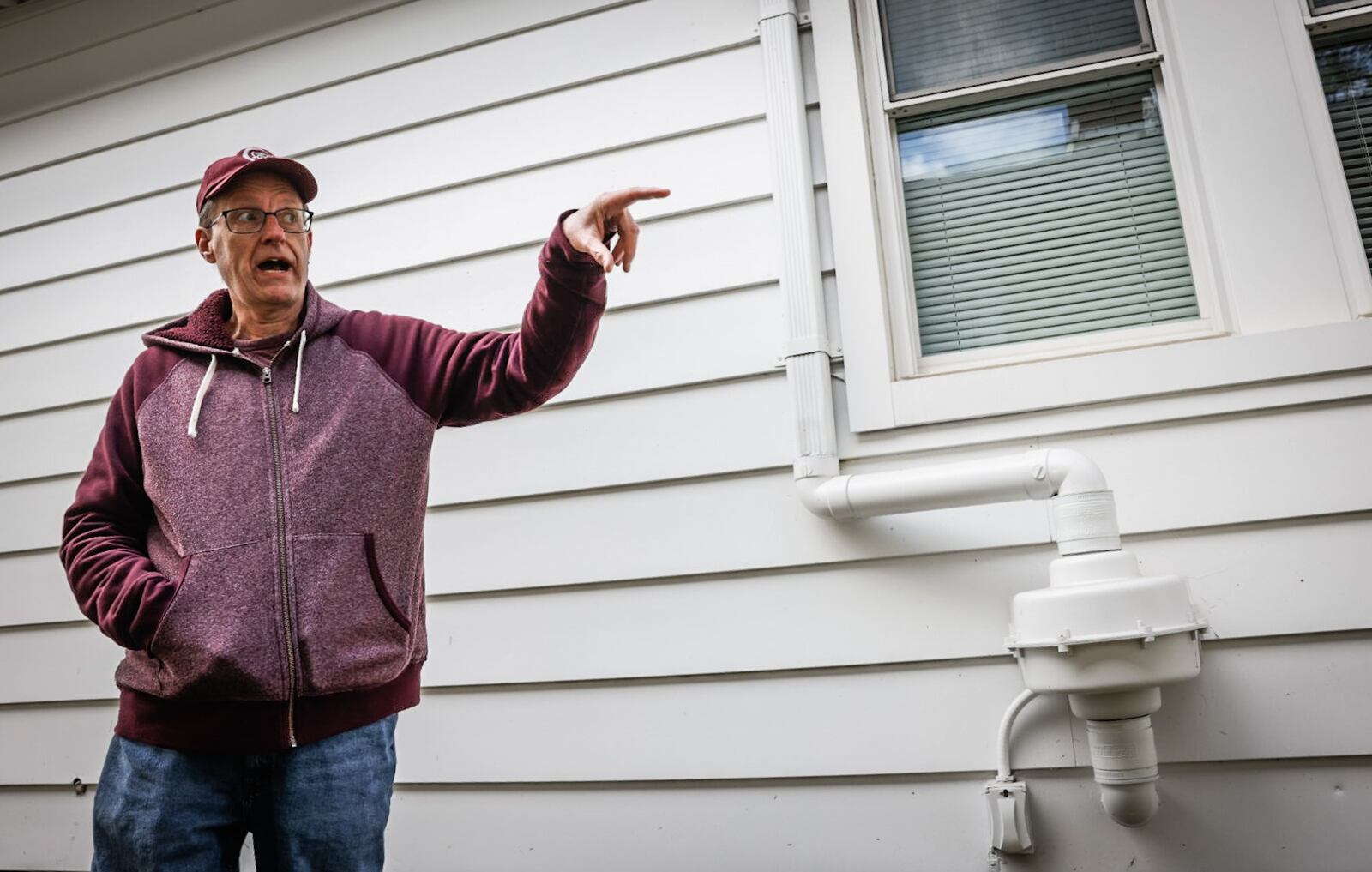 Jerry Bowling, III, president of the McCook Field Neighborhood Association points out a mitigation system to alleviate chemicals that seep into residents basements. JIM NOELKER/STAFF