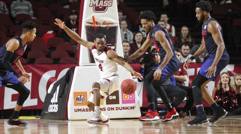 Dayton and Massachusetts eye a loose ball in the first half on Saturday, Feb. 3, 2018, at the Mullins Center in Amherst, Mass.
