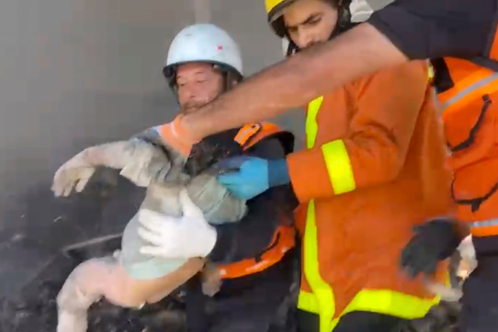 In this frame grab from a video released by Gaza Civil Defense, workers collect the remains a a child after an Israeli strike on a home in Khan Younis killed nine of a doctor's ten children while she was at work, according to Ahmad al-Farra, head of the pediatric department at Nasser Hospital, in Khan Younis, Gaza Strip, Saturday, May 24, 2025. (Gaza Civil Defense via AP)