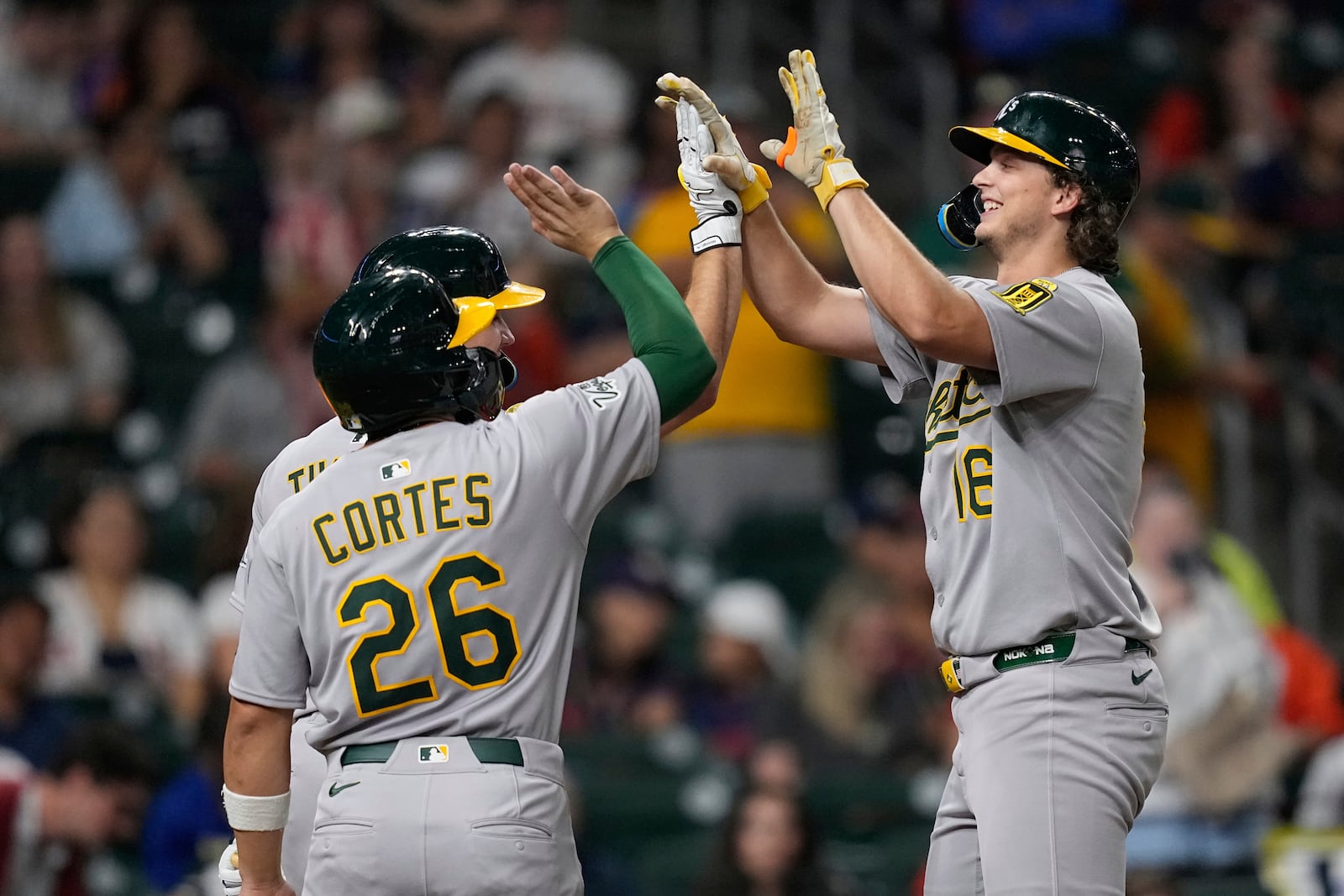 Athletics' Nick Kurtz (16) celebrates with Carlos Cortes (26) and Gio Urshela after hitting a three-run home against the Houston Astros during the ninth inning of a baseball game Friday, July 25, 2025, in Houston. (AP Photo/David J. Phillip)
