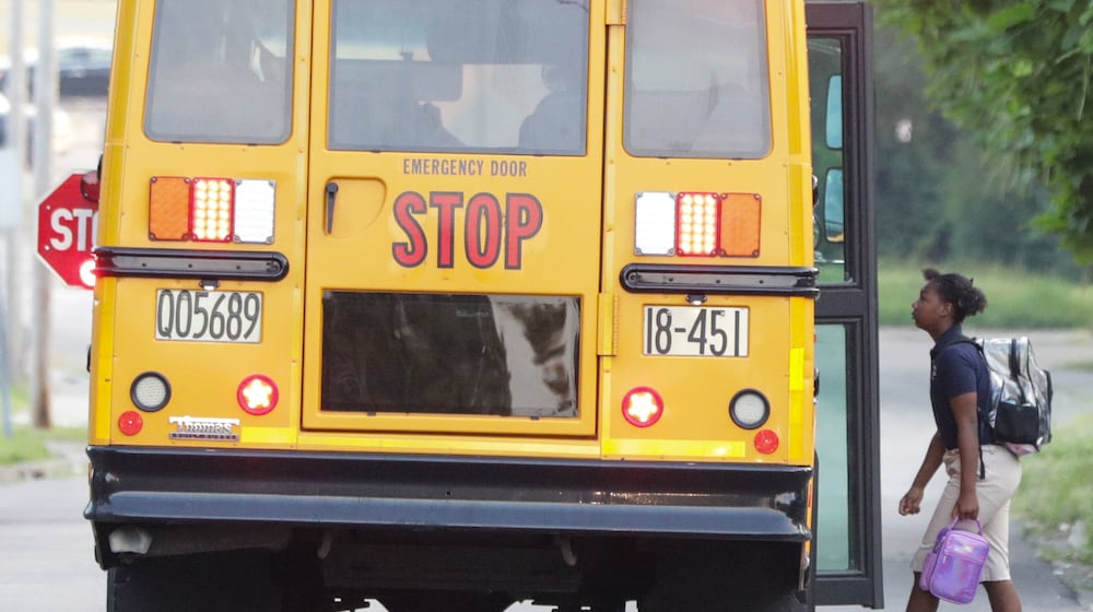 A child walks onto a Dayton Public Schools bus on Dearborn Avenue on Tuesday, Aug. 12. It was the first day of school for many Dayton Public Schools students. BRYANT BILLING / STAFF