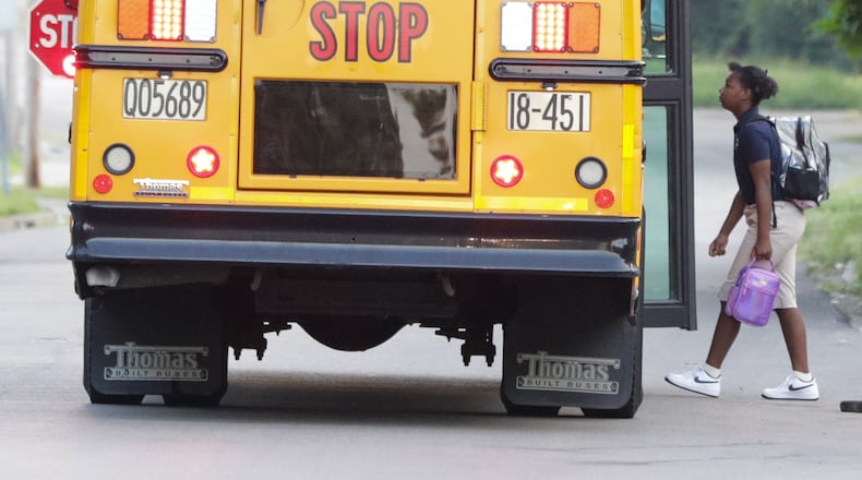 A child walks onto a Dayton Public Schools bus on Dearborn Avenue on Tuesday, Aug. 12. It was the first day of school for many Dayton Public Schools students. The school district has filed a lawsuit against the state of Ohio to stop enforcement of a provision in the recent budget to block students from using school-purchased RTA passes to change buses in downtown bus hub. BRYANT BILLING / STAFF