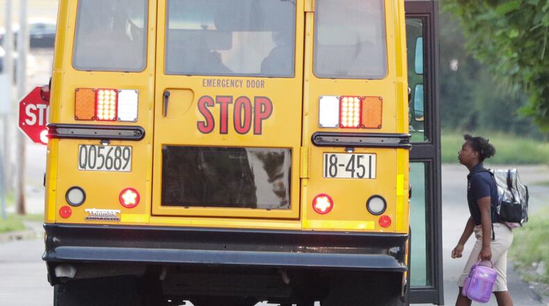 A child walks onto a Dayton Public Schools bus on Dearborn Avenue on Tuesday, Aug. 12. BRYANT BILLING / STAFF