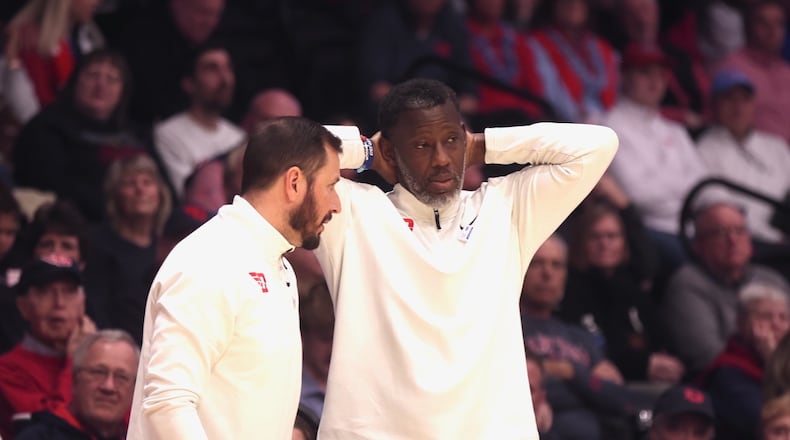 Dayton's Anthony Grant reacts to a play during a game against Rhode Island as James Kane talks to him on Tuesday, Jan. 27, 2026, at UD Arena. David Jablonski/Staff