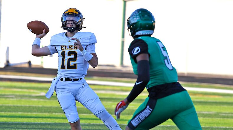 Centerville quarterback Drake Wells throws under pressure from Northmont's Cedric Works. BILL LACKEY/STAFF