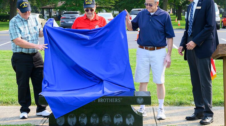 From left: Steve, Larry and Jerry Litten unveil a memorial bench honoring them and four other brothers during a ceremony July 20 at the National Museum of the U.S. Air Force. At right is Jim Blackman, a museum volunteer. The seven Litten brothers served a combined total of 137 years in the Air Force. U.S. AIR FORCE PHOTO/R.J. ORIEZ