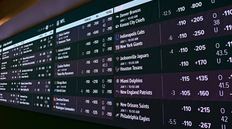 Screens display betting information inside Caesars Sportsbook inside Rocket Mortgage FieldHouse, Thursday, Dec. 29, 2022, in Cleveland. Sportsbook operators, or their affiliate marketers, are facing proposed fines from the Ohio Casino Control Commission for alleged advertising violations. (AP Photo/David Dermer)