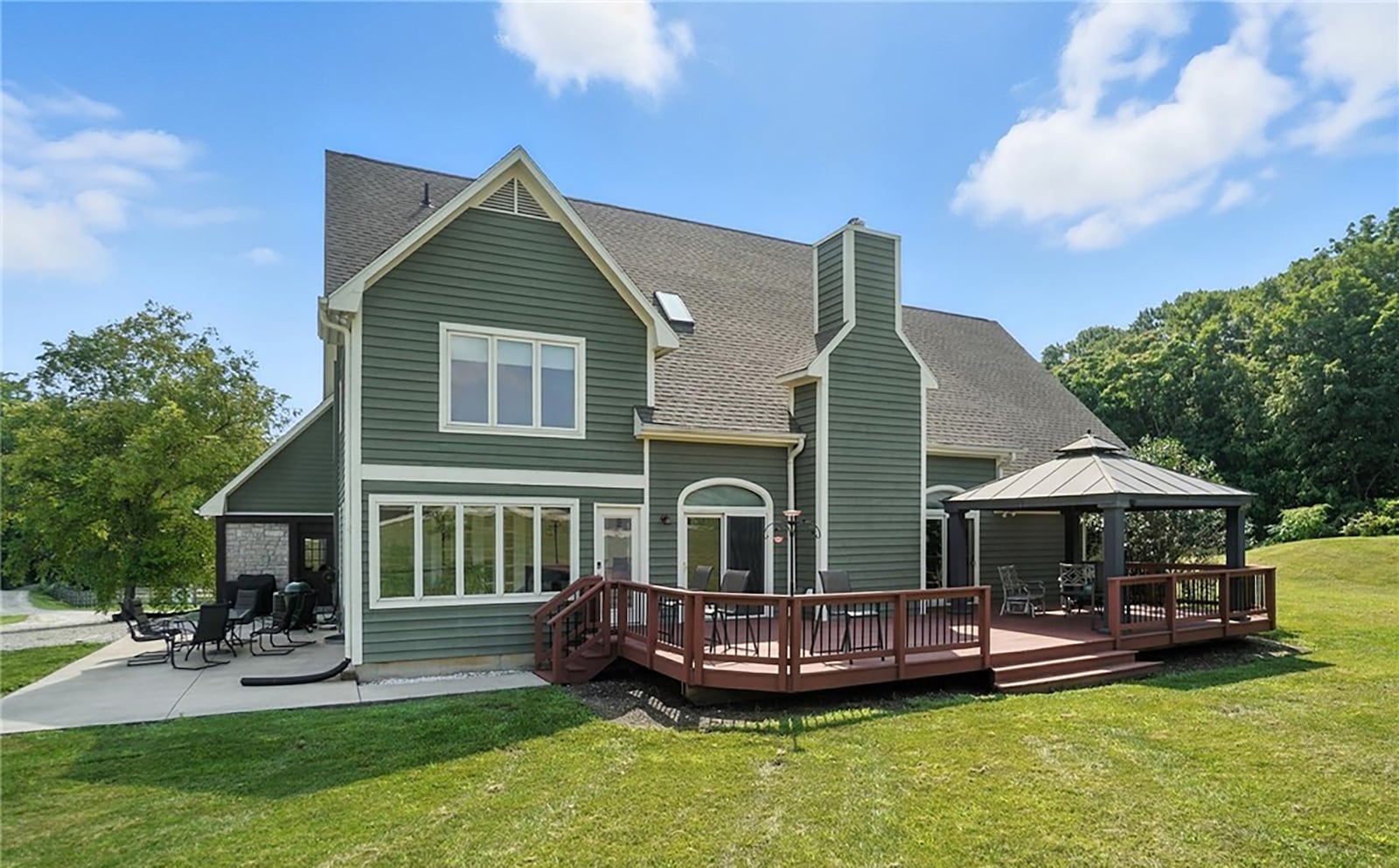 The rear of the home has a wood deck with railings and a gazebo and a concrete patio that wraps around the side. CONTRIBUTED