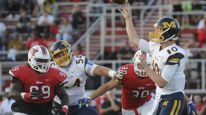 Wayne’s Mazon Walker (99) and Alex Reigelsperger close on Moeller QB Evan Ernst. Wayne hosted Moeller in a Week 2 high school football game at Heidkamp Stadium on Friday, Sept. 2, 2016. MARC PENDLETON / STAFF