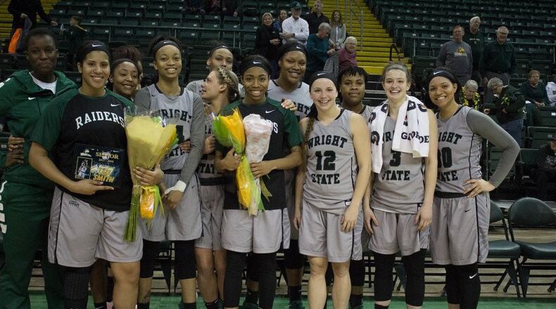 Lexi Smith (left) and Chelsea Welch hold flowers surrounded by their teammates at Senior Day festivities following Wright State’s 70-63 women’s basketball victory over Northern Kentucky. ALLISON RODRIGUEZ / CONTRIBUTED