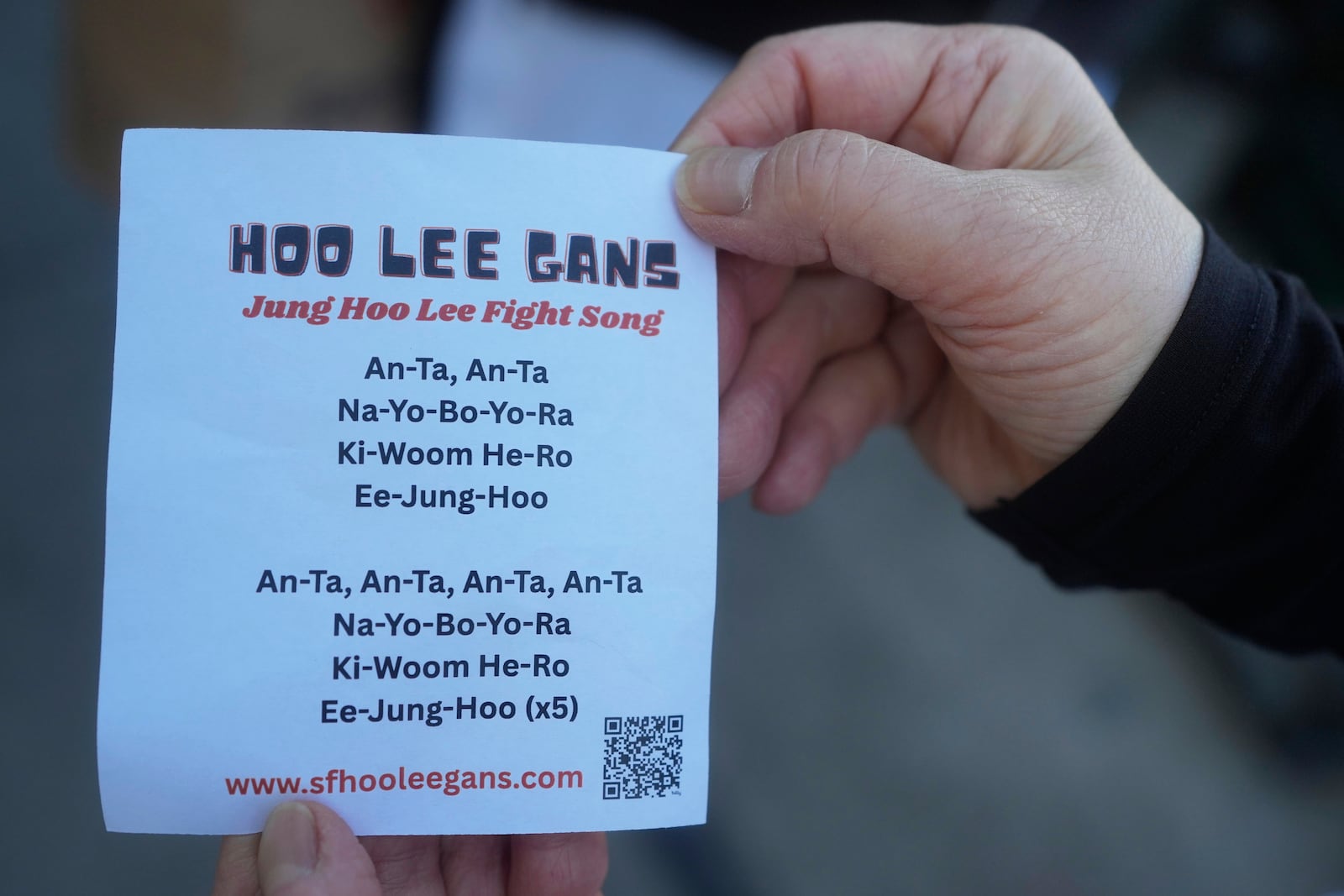 A fan of San Francisco Giants' Jung Hoo Lee, who call themselves Hoo Lee Gans, holds up the words to a fight song for Lee before a baseball game between the Giants and the Arizona Diamondbacks in San Francisco, Tuesday, May 13, 2025. (AP Photo/Jeff Chiu)