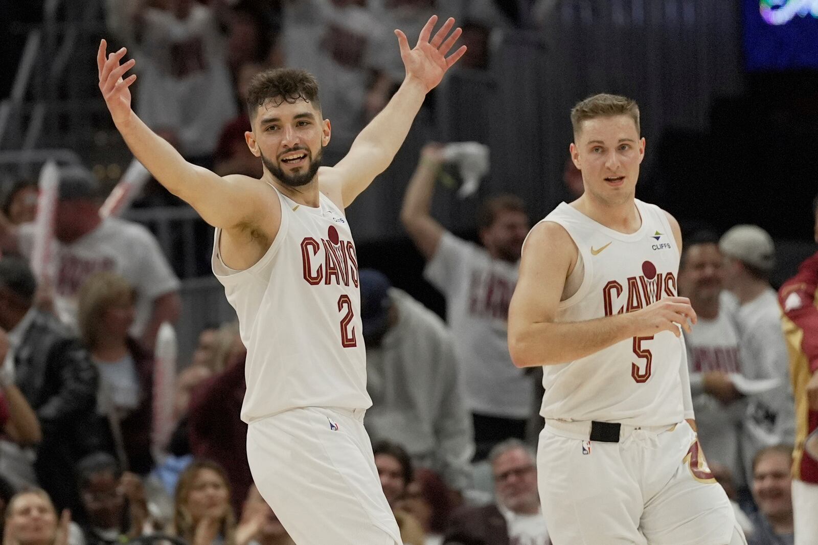 Cleveland Cavaliers guard Ty Jerome (2) celebrates in front of teammate Sam Merrill in the second half in Game 1 of an NBA first-round playoff series against the Miami Heat, Sunday, April 20, 2025, in Cleveland. (AP Photo/Sue Ogrocki)