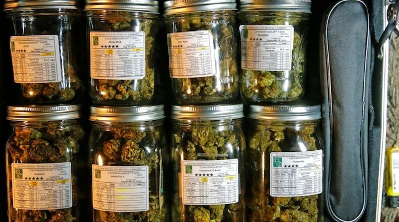 A small suitcase with Mason jars of medical marijuana at the Laguna Woods, Calif., retirement community's medical marijuana collective in an October 2014 file image. A comprehensive new report says the precise health effects of marijuana on those who use it remain something of a mystery -- and the federal government continues to erect major barriers to research that would provide much-needed answers. (Don Bartletti/Los Angeles Times/TNS)