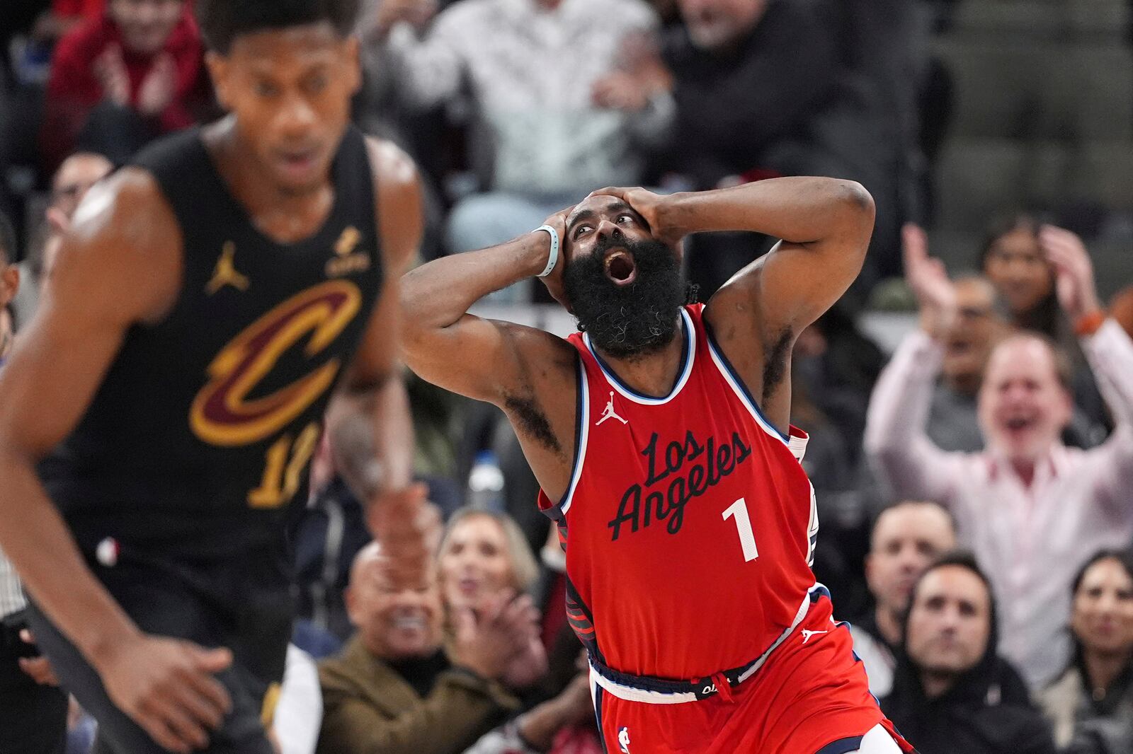 Los Angeles Clippers guard James Harden, right, celebrates after scoring as Cleveland Cavaliers forward De'Andre Hunter runs by during the second half of an NBA basketball game Tuesday, March 18, 2025, in Inglewood, Calif. (AP Photo/Mark J. Terrill)