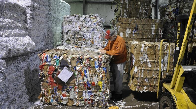 Roger Smart records the tonnage for recycled bales of paper stacked high inside the Base Recycling Center, Bldg. 293, Area A, Wright-Patterson Air Force Base. (U.S. Air Force photo/W. Eugene Barnett Jr.)