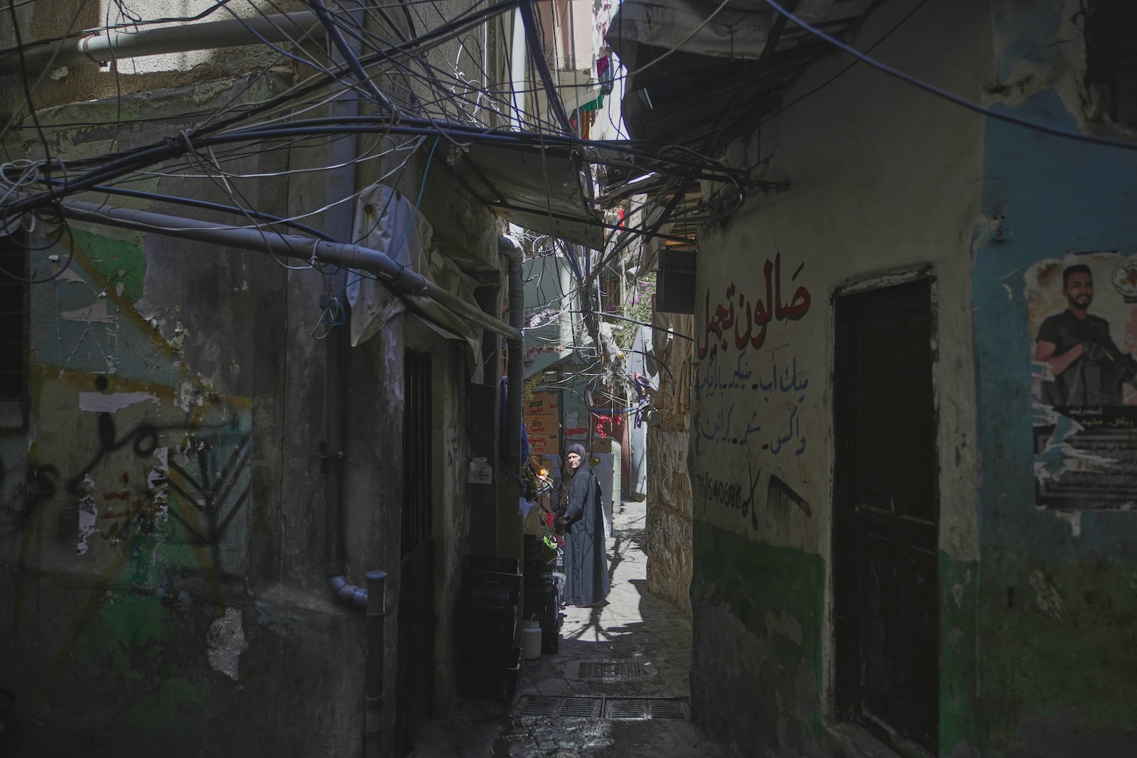 A woman walks through a narrow alley in the Mar Elias refugee camp in Beirut, Lebanon, Monday, June 2, 2025. (AP Photo/Hassan Ammar)