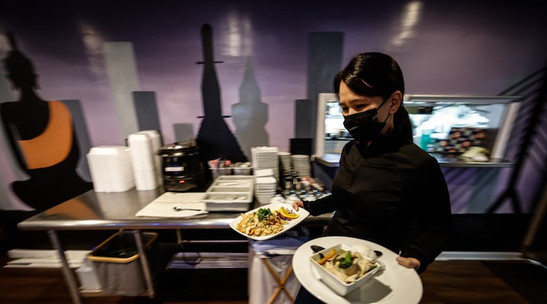 Thai Table manager, Pom Hmornvattanavong, serves food at the restaurant on Far Hill Ave. Monday March 14, 2022. Two years ago, Ohio shut down bars and indoor dining for two-and-a-half months in hopes of stopping the spread of COVID-19. JIM NOELKER/STAFF