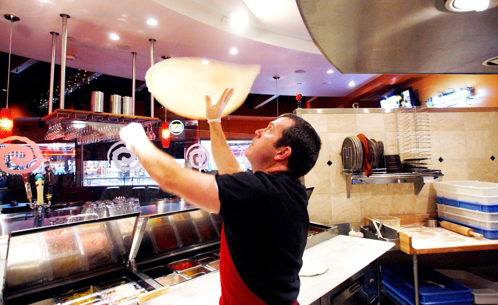 Owner Glen Brailey of Spinoza's Pizza prepares pizza dough at the restaurant inside the Mall at Fairfield Commons. Brailey and his staff are gearing up for Black Friday with seasonal craft beers, giveaways, radio promotion with the hopes to best accommodate guests during one of the biggest shopping days of the year.