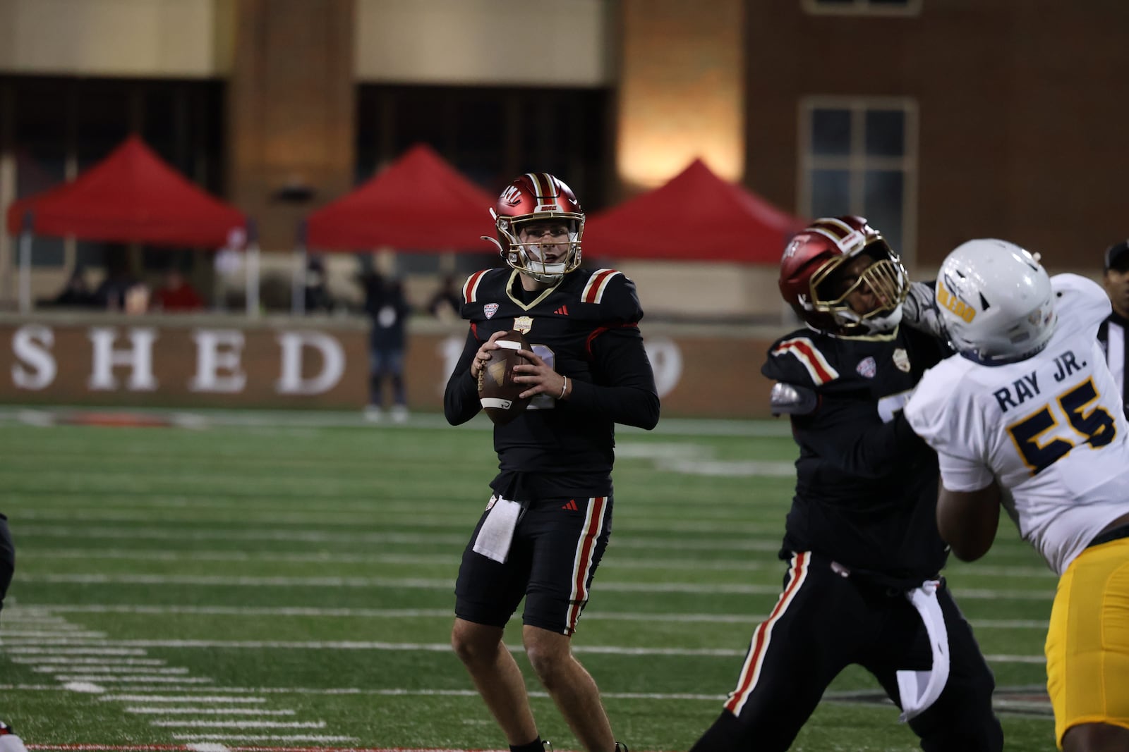 Miami's Henry Hesson (12) drops back to pass against Toledo on Wednesday night at Yager Stadium. The RedHawks lost 24-3. ELIJAH COOK / CONTRIBUTED