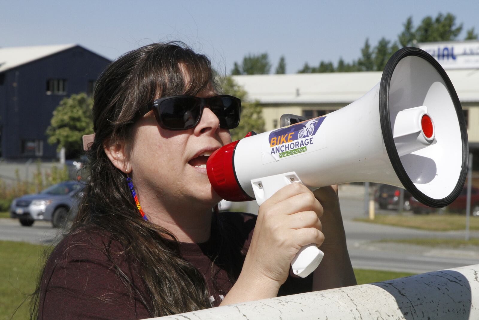Demonstrator Courtney Moore uses a bullhorn Thursday, June 12, 2025, in Anchorage, Alaska, to protest the detainment of about 40 people being held there under the custody of the Immigration and Customs Enforcement federal agency. (AP Photo/Mark Thiessen)