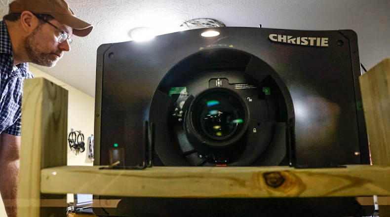 Matt Fields from Doan Theatre Services works to install a new 4K laser projector at the Plaza Theatre Wednesday December 6, 2023. It replaced a 2K lamp projector. JIM NOELKER/STAFF
