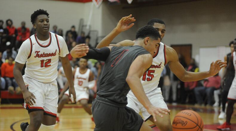 Wayne’s Deshon Parker (with ball) is checked by Trotwood’s Malachi Mathews (12) and Justin Stephens. Wayne defeated host Trotwood-Madison 90-87 in double-OT in a boys high school basketball game last Friday. MARC PENDLETON / STAFF