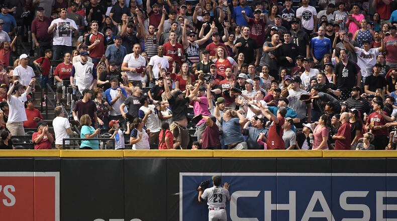 PHOENIX, AZ - MAY 28:  Adam Duvall #23 of the Cincinnati Reds watches as fans reach for the home run ball hit by John Ryan Murphy #36 of the Arizona Diamondbacks (not pictured) during the fourth inning of the MLB game at Chase Field on May 28, 2018 in Phoenix, Arizona. MLB players across the league are wearing special uniforms to commemorate Memorial Day.  (Photo by Jennifer Stewart/Getty Images)