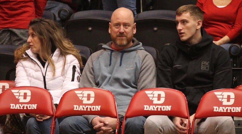 Chase Johnson, right, sits with his parents behind the Dayton bench during a game against Georgia Southern on Dec. 29, 2018, at UD Arena. David Jablonski/Staff