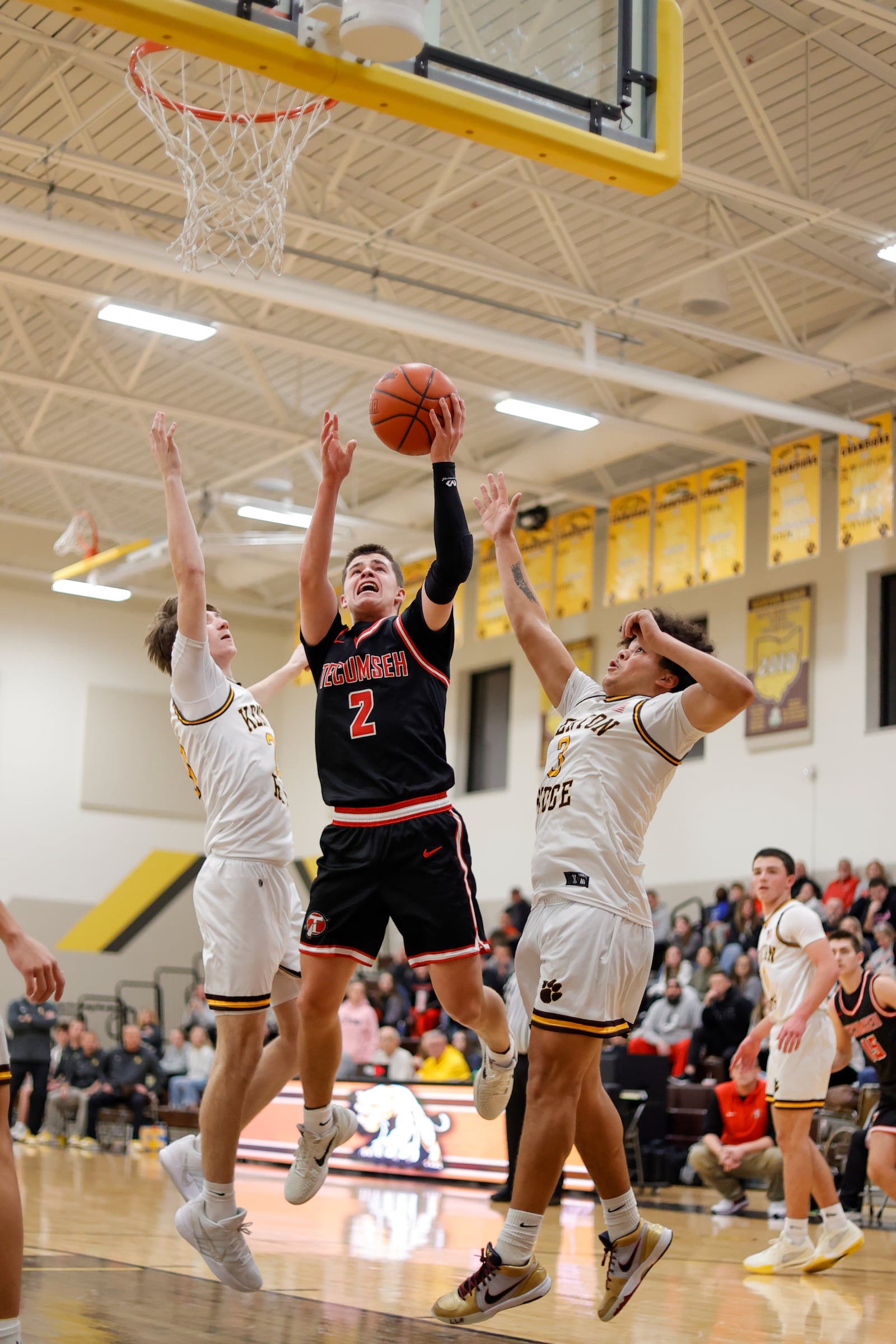Tecumseh senior Chase Stafford drives past Kenton Ridge junior Preston Smith and senior Caleb Hall during their game on Friday, Dec. 5, 2025 in Springfield. The Cougars won 69-60. MICHAEL COOPER / STAFF PHOTO