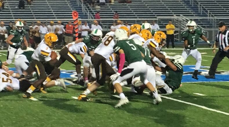 Marshall Flaig (5) is among the Badin defenders eyeing Alter running back John Bivens (3) during Friday night's game at Hamilton's Virgil Schwarm Stadium. RICK CASSANO/STAFF