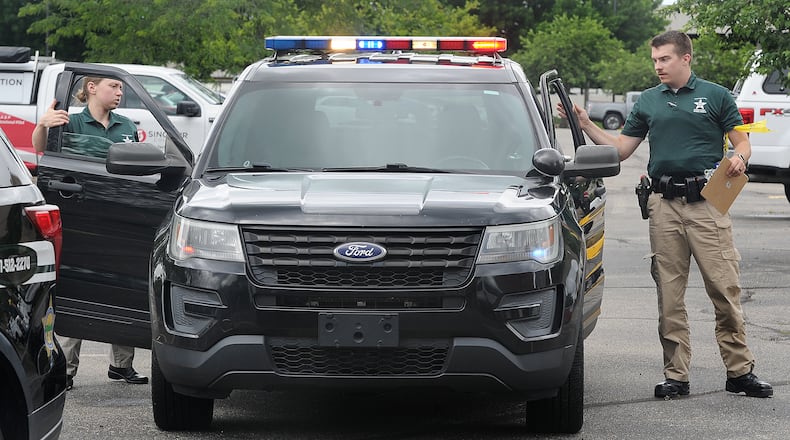 Reporter London Bishop and cadet Noah Thomas exit a cruiser during combined scenarios training at the Sinclair Police Academy. MARSHALL GORBY\STAFF