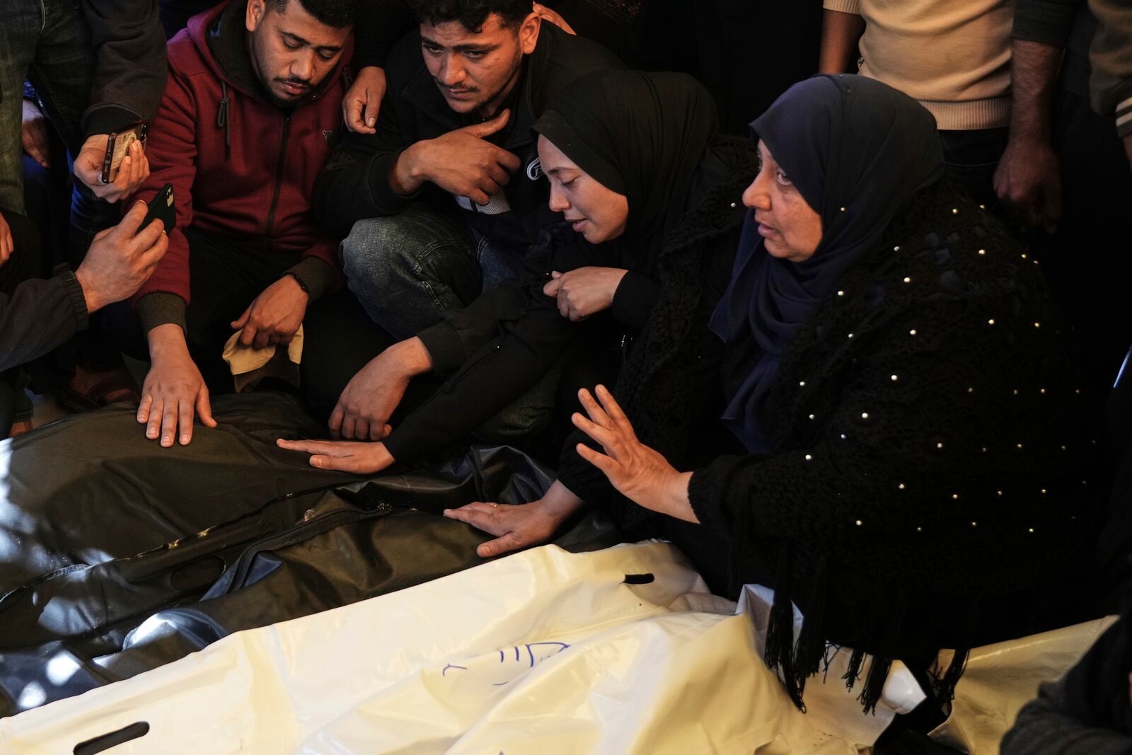 Relatives Mourn over the bodies of 10 members of the Abu Al-Rous family, killed when an Israeli airstrike struck their displacement tent overnight, during their funeral in Khan Younis, southern Gaza Strip, Thursday, April 17, 2025. (AP Photo/Abdel Kareem Hana)