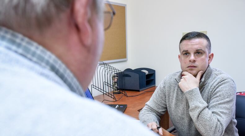Casey James, right, service officer with the Butler County Veterans Service Commission, meets with a client in the Middletown branch office on Breiel Boulevard. NICK GRAHAM/STAFF